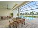 Enjoy outdoor dining with lake views on the screened-in lanai with a pool and comfortable seating area at 8332 Sea Glass Ct, Sarasota, FL 34240