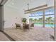 Stylish outdoor patio featuring comfortable seating and a ceiling fan, overlooking a sparkling pool and lake at 8332 Sea Glass Ct, Sarasota, FL 34240