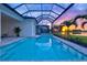 Inviting pool area with a screened enclosure, jacuzzi, and picturesque lake view at sunset at 8332 Sea Glass Ct, Sarasota, FL 34240