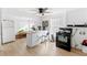 Galley kitchen with island, white cabinets, and black appliances at 1501 14Th W Ave, Bradenton, FL 34205