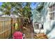 Small backyard with brick pathway, wooden fence, and a red chair at 1501 14Th W Ave, Bradenton, FL 34205