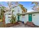 Light teal home with green door, mature trees, and parking area at 1501 14Th W Ave, Bradenton, FL 34205