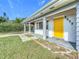 Bright yellow door and white brick facade accent this home at 2877 Michigan St, Sarasota, FL 34237