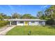 Ranch style home with yellow door and a spacious green lawn at 2877 Michigan St, Sarasota, FL 34237