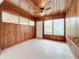 Sunroom with wood paneled walls, ceiling fan and windows at 2877 Michigan St, Sarasota, FL 34237