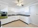 Bright kitchen with white cabinets and a ceiling fan at 2877 Michigan St, Sarasota, FL 34237
