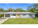A charming ranch-style home with a yellow door and well-maintained lawn at 2877 Michigan St, Sarasota, FL 34237