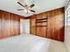 Bedroom with wood-paneled walls and ceiling fan at 2877 Michigan St, Sarasota, FL 34237