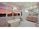 Large bathroom with free-standing tub, updated vanity, and sunset views at 309 Ringling Point Dr, Sarasota, FL 34234