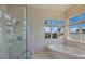 Spa-like bathroom with soaking tub, walk-in shower, and water views at 309 Ringling Point Dr, Sarasota, FL 34234