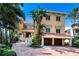 Mediterranean-style home features a brick driveway, two-car garage, and lush landscaping at 309 Ringling Point Dr, Sarasota, FL 34234