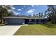 Charming single-story home featuring a two-car garage, well-manicured lawn, and stylish architectural details at 3249 Vickers Ln, North Port, FL 34286