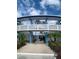 The Dorset: Exterior view of building, showing walkway, landscaping, and unique architectural details at 475 Benjamin Franklin Dr # 202, Sarasota, FL 34236