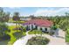 Single story home with red tile roof, lush landscaping, and water view at 5156 Little Brook Ct, Sarasota, FL 34238
