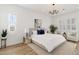 Bright bedroom with a king-size bed, light wood floors, and plantation shutters at 5156 Little Brook Ct, Sarasota, FL 34238