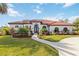 White house with red tile roof, landscaping, and a paved driveway at 5156 Little Brook Ct, Sarasota, FL 34238