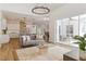 Open living room with hardwood floors, gray sofa, and view of the kitchen at 5156 Little Brook Ct, Sarasota, FL 34238