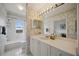 Bathroom with white vanity, decorative wallpaper, and a tub/shower combination with a window at 5450 Eagles Point Cir # 405, Sarasota, FL 34231