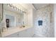 Bathroom with white vanity, decorative wallpaper, and a large mirror with vanity lights at 5450 Eagles Point Cir # 405, Sarasota, FL 34231