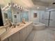 Bright bathroom featuring a soaking tub, glass shower, and double sink vanity with a large mirror at 5450 Eagles Point Cir # 405, Sarasota, FL 34231