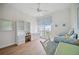 Bedroom featuring white decor, wood floors, and a window with blue patterned curtains at 5450 Eagles Point Cir # 405, Sarasota, FL 34231
