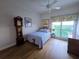 Bright bedroom features wood floors, ceiling fan, and a large window with decorative curtains at 5450 Eagles Point Cir # 405, Sarasota, FL 34231