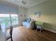Bright bedroom features wood floors, ceiling fan, and a large window with blue patterned curtains at 5450 Eagles Point Cir # 405, Sarasota, FL 34231
