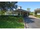 Exterior view of the clubhouse showing mature landscaping, covered entrance and circular driveway at 5450 Eagles Point Cir # 405, Sarasota, FL 34231