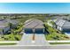 Aerial view of two-story home with three-car garage and paver driveway at 5514 Tidal Breeze Cv, Bradenton, FL 34211