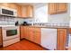 Kitchen features white appliances and wood cabinets at 560 Bradenton Rd, Venice, FL 34293