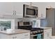 Bright kitchen with stainless steel gas range and microwave at 6927 Lennox Pl, University Park, FL 34201