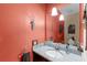 Powder room with single vanity and coral walls at 7917 Broadmoor Pines Blvd, Sarasota, FL 34243