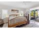 Main bedroom with wood bed frame and access to backyard patio at 7917 Broadmoor Pines Blvd, Sarasota, FL 34243