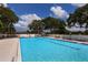 Community swimming pool with lounge chairs and tables at 7917 Broadmoor Pines Blvd, Sarasota, FL 34243