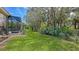 Landscaped backyard with a grassy area and screened enclosure at 9506 Royal Calcutta Pl, Lakewood Ranch, FL 34202