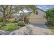 Tan house with red door, mature trees, and a basketball hoop at 9506 Royal Calcutta Pl, Lakewood Ranch, FL 34202