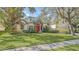 Beautiful one-story home with a red door, lush landscaping, and a large green lawn at 9506 Royal Calcutta Pl, Lakewood Ranch, FL 34202