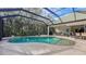 Relaxing kidney-shaped pool with a screened enclosure, patio, and lush landscaping at 9506 Royal Calcutta Pl, Lakewood Ranch, FL 34202