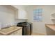Laundry room with washer, dryer, sink, and ample storage at 9506 Royal Calcutta Pl, Lakewood Ranch, FL 34202