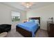 Bedroom features a wood bed frame, blue comforter, ceiling fan, and window with blinds at 1010 Tidewater Shores Loop # 201, Bradenton, FL 34208