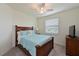 Bedroom features a wood bed frame, blue comforter, ceiling fan, and window with blinds at 1010 Tidewater Shores Loop # 201, Bradenton, FL 34208