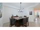 Dining room with dark wood table, four chairs, modern chandelier, and neutral decor at 1010 Tidewater Shores Loop # 201, Bradenton, FL 34208