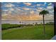 Scenic waterfront view at sunset with palm trees and lush grass at 1010 Tidewater Shores Loop # 201, Bradenton, FL 34208