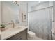 Modern bathroom with gray vanity and patterned shower curtain at 10180 Canaveral Cir, Sarasota, FL 34241