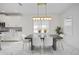 Dining area with dark gray table, white chairs, and chandelier at 10180 Canaveral Cir, Sarasota, FL 34241