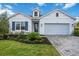 White house with blue shutters, landscaped yard, and paver driveway at 10180 Canaveral Cir, Sarasota, FL 34241