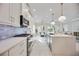 Modern kitchen features white cabinets, gas range, and subway tile backsplash at 10180 Canaveral Cir, Sarasota, FL 34241