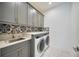 Laundry room with gray cabinets, a sink, and stacked washer/dryer at 10180 Canaveral Cir, Sarasota, FL 34241