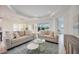 Bright living room featuring two sofas, a coffee table, and large windows at 10180 Canaveral Cir, Sarasota, FL 34241