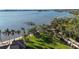 Aerial view of waterfront property with lush lawn and tropical trees at 111 Webb St, Osprey, FL 34229